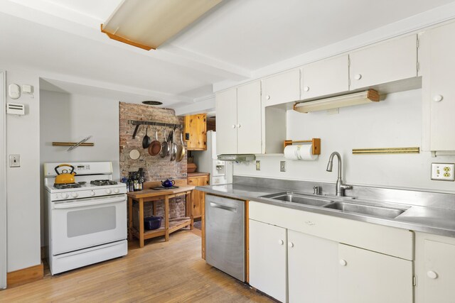 42 Winthrop St, Hallowell, ME 04347 - kitchen featuring stainless steel counters, white range with gas cooktop, dishwasher, a sink, and light wood-style floors