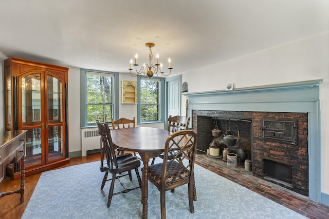 42 Winthrop St, Hallowell, ME 04347 - dining room featuring a stone fireplace, radiator heating unit, and a chandelier
