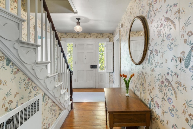 42 Winthrop St, Hallowell, ME 04347 - foyer featuring wallpapered walls, radiator heating unit, light wood-type flooring, and stairs