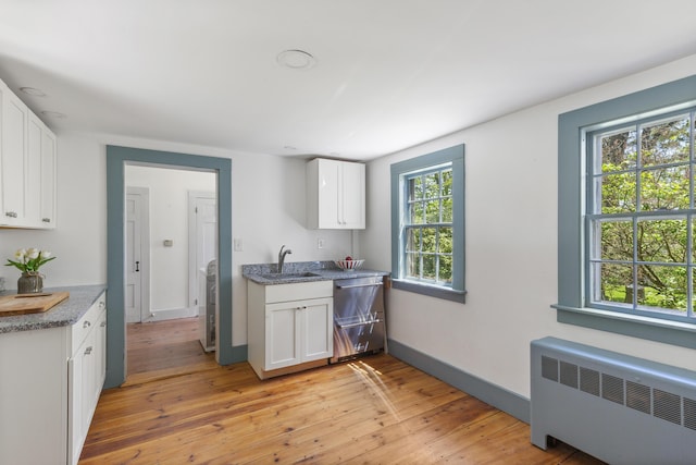 42 Winthrop St, Hallowell, ME 04347 - kitchen featuring radiator heating unit, a sink, dishwasher, light wood-style flooring, and white cabinets