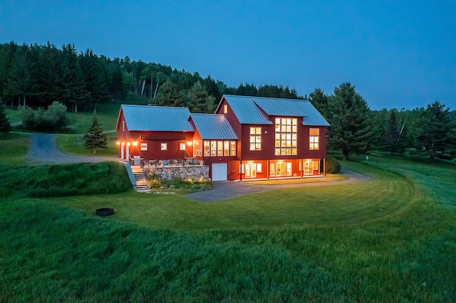 39 Kendall Farm Trl, Rangeley, ME 04970 - back of house with a yard, a metal roof, a view of trees, and dirt driveway