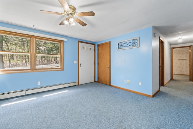 unfurnished room with a baseboard radiator, ceiling fan, carpet floors, and baseboards