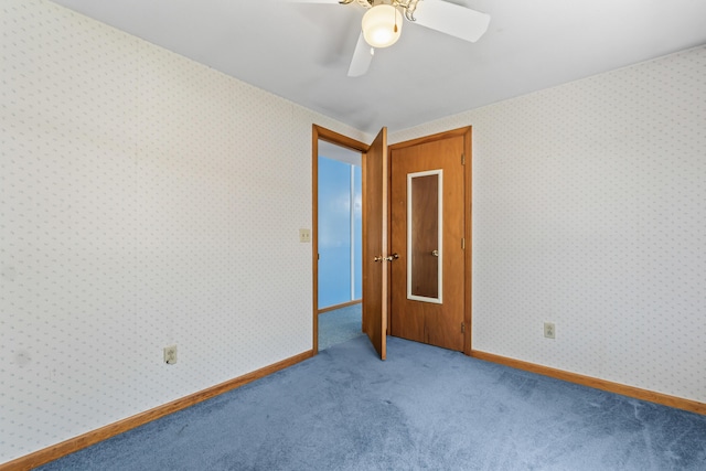 carpeted empty room with a ceiling fan