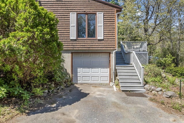 view of front facade with asphalt driveway, stairs, and a garage