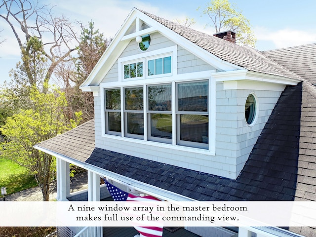 view of side of property with a shingled roof and a chimney