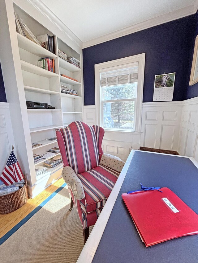 rec room featuring wainscoting, ornamental molding, and built in shelves