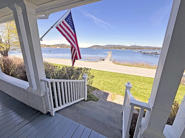 wooden deck featuring a lawn and a water and mountain view
