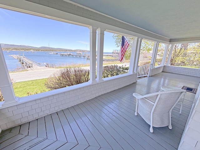 unfurnished sunroom with a water view, plenty of natural light, and hardwood / wood-style flooring