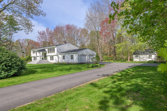 56 Carroll St, Falmouth, ME 04105 - view of front of home with a chimney, asphalt driveway, an attached garage, and a front yard
