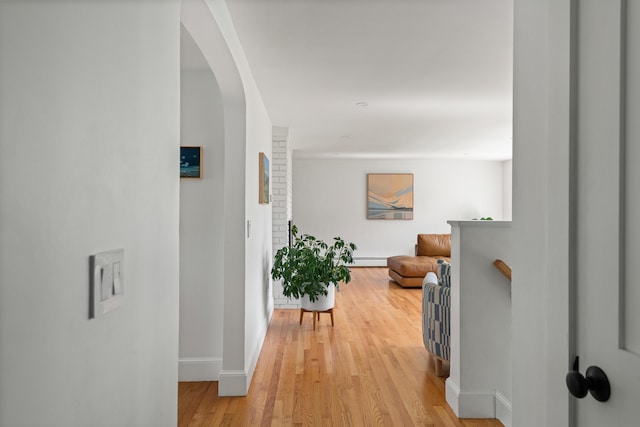 56 Carroll St, Falmouth, ME 04105 - hall with baseboards, light wood-style floors, arched walkways, and a baseboard radiator