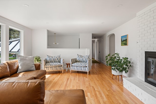 56 Carroll St, Falmouth, ME 04105 - living room featuring a brick fireplace, light wood finished floors, and baseboards