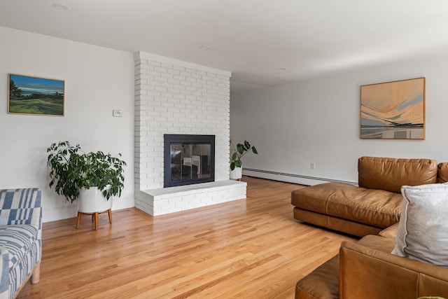 56 Carroll St, Falmouth, ME 04105 - living room featuring a baseboard heating unit, wood finished floors, and a brick fireplace