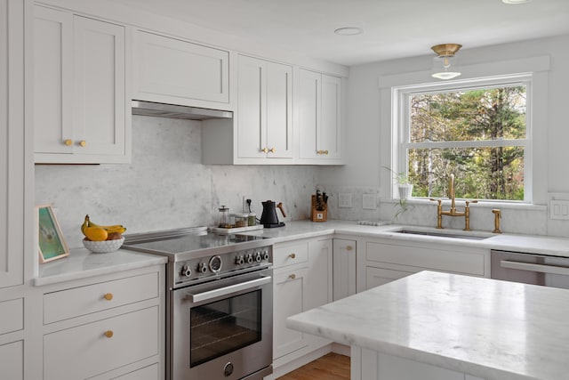 56 Carroll St, Falmouth, ME 04105 - kitchen featuring stainless steel appliances, a sink, under cabinet range hood, white cabinetry, and backsplash