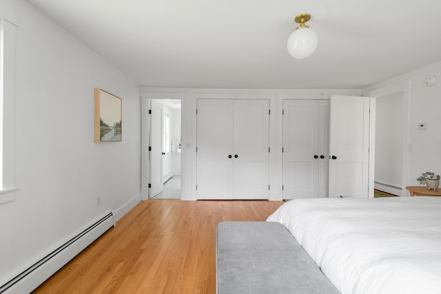 56 Carroll St, Falmouth, ME 04105 - bedroom featuring a baseboard heating unit, multiple closets, light wood finished floors, and baseboards