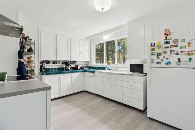 38 Falmouth Rd, Falmouth, ME 04105 - kitchen with white appliances, white cabinetry, wall chimney range hood, a sink, and tile countertops