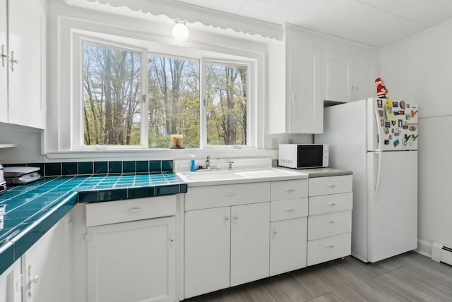 38 Falmouth Rd, Falmouth, ME 04105 - kitchen featuring white appliances, white cabinetry, a sink, tile countertops, and wood finished floors