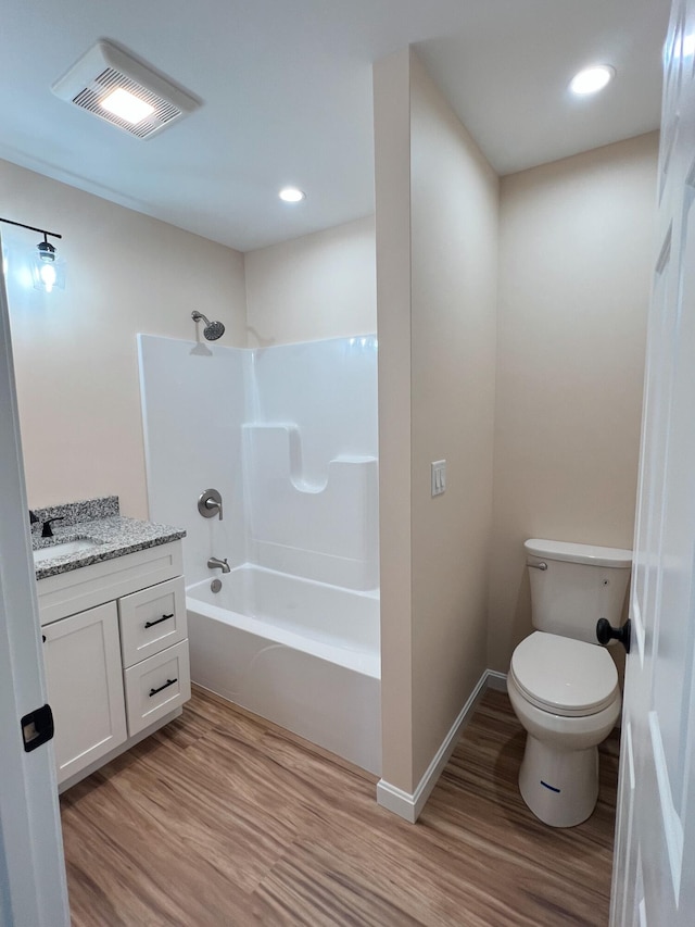 full bath featuring wood finished floors, toilet, vanity, washtub / shower combination, and baseboards