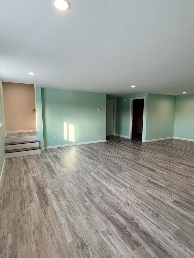 unfurnished living room featuring wood finished floors, baseboards, and recessed lighting