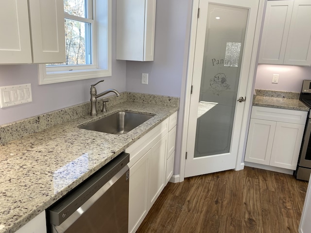 kitchen featuring stainless steel dishwasher, a sink, and white cabinets