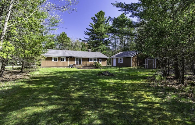 29 Fields Pond Rd, Holden, ME 04429 - back of property featuring a storage unit, an outbuilding, a yard, and metal roof