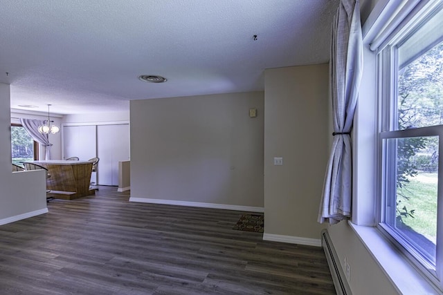 29 Fields Pond Rd, Holden, ME 04429 - unfurnished living room with dark wood-type flooring, a textured ceiling, baseboards, a chandelier, and a baseboard radiator