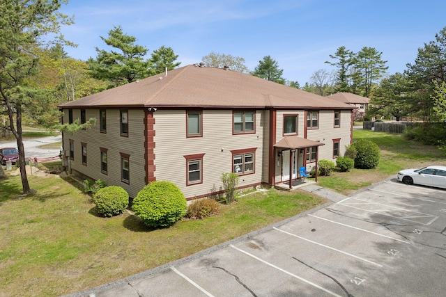 view of front of property featuring uncovered parking and a front lawn