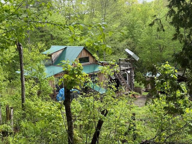 103 Fellows Ln, Winthrop, ME 04364 - exterior space featuring a forest view, stairway, and metal roof