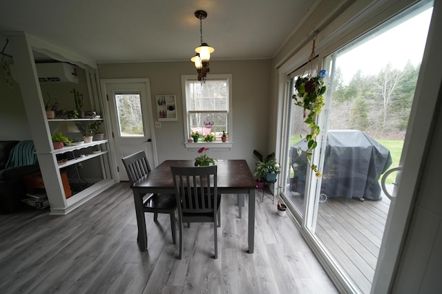 176 Smyrna Center Rd, Smyrna, ME 04780 - dining space with wood finished floors, an AC wall unit, and crown molding