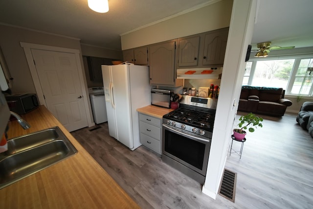 176 Smyrna Center Rd, Smyrna, ME 04780 - kitchen with stainless steel gas range oven, white fridge with ice dispenser, under cabinet range hood, black microwave, and a sink