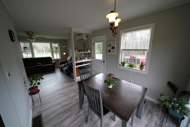 176 Smyrna Center Rd, Smyrna, ME 04780 - dining area featuring a wall unit AC, a ceiling fan, and light wood finished floors