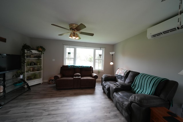 176 Smyrna Center Rd, Smyrna, ME 04780 - living room featuring wood finished floors, a wall mounted air conditioner, ceiling fan, and baseboards