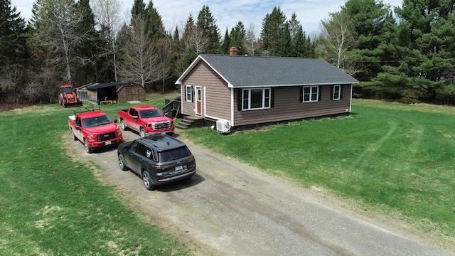 176 Smyrna Center Rd, Smyrna, ME 04780 - view of front of property with driveway, a shingled roof, an outbuilding, a chimney, and a front yard
