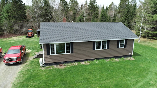 176 Smyrna Center Rd, Smyrna, ME 04780 - view of front of house with a shingled roof, a chimney, a front lawn, and a view of trees