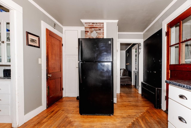 10 River St, Strong, ME 04983 - kitchen with freestanding refrigerator, white cabinets, dark countertops, and crown molding