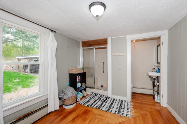 10 River St, Strong, ME 04983 - bedroom with a baseboard heating unit, multiple windows, and wooden walls