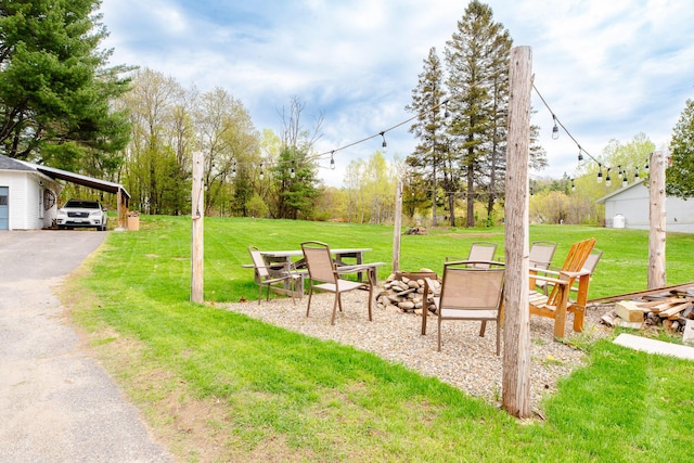 10 River St, Strong, ME 04983 - view of grassy yard featuring an outdoor fire pit and driveway