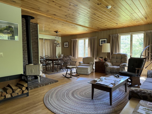 898 Sebec Village Rd, Sebec, ME 04481 - living room featuring a wood stove, wood ceiling, wood finished floors, and wooden walls