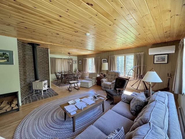 898 Sebec Village Rd, Sebec, ME 04481 - living area featuring wooden ceiling, a wall mounted AC, a wood stove, wood finished floors, and baseboard heating