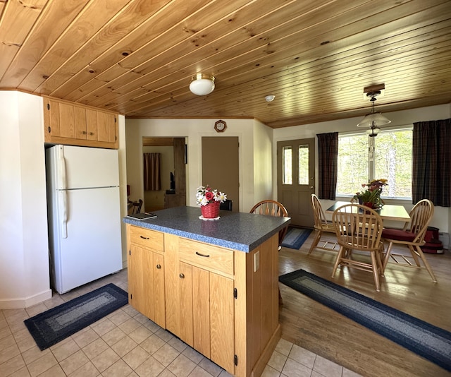 898 Sebec Village Rd, Sebec, ME 04481 - kitchen featuring freestanding refrigerator, dark countertops, light tile patterned flooring, wooden ceiling, and a center island
