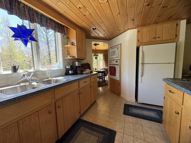 898 Sebec Village Rd, Sebec, ME 04481 - kitchen with white appliances, dark countertops, wood ceiling, light tile patterned flooring, and a sink
