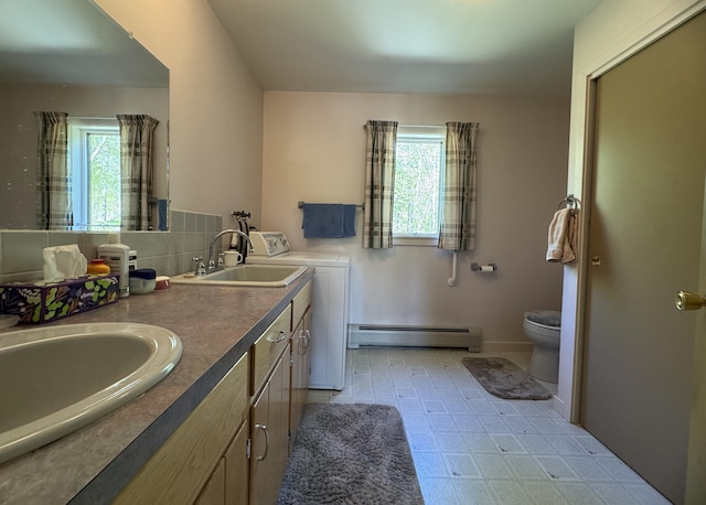 898 Sebec Village Rd, Sebec, ME 04481 - bathroom featuring baseboard heating, washer and dryer, healthy amount of natural light, and toilet