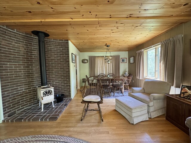 898 Sebec Village Rd, Sebec, ME 04481 - living area with a wood stove, light wood finished floors, and wood ceiling