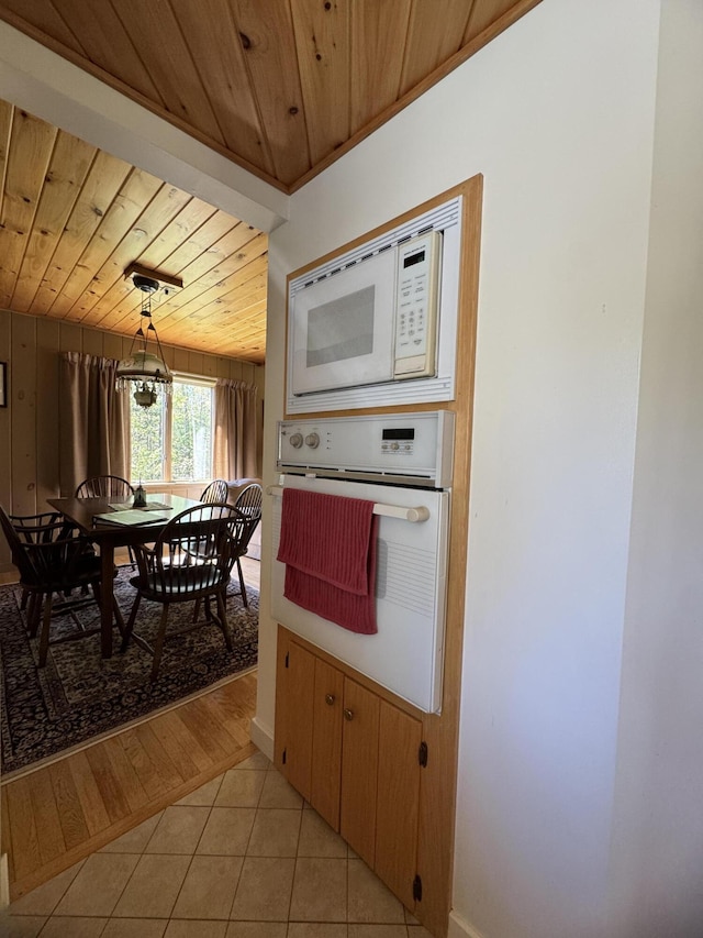 898 Sebec Village Rd, Sebec, ME 04481 - kitchen with white appliances, wood ceiling, light tile patterned flooring, baseboards, and pendant lighting
