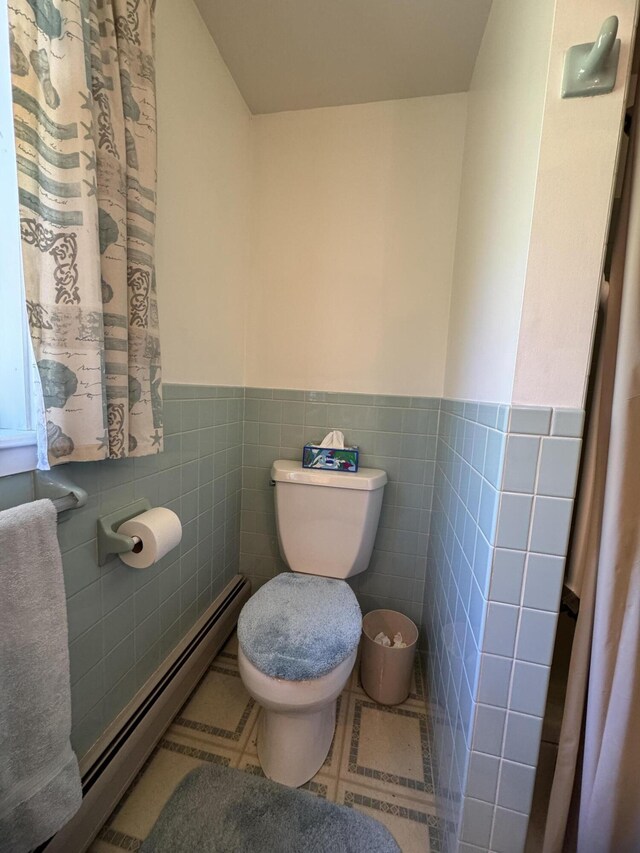 898 Sebec Village Rd, Sebec, ME 04481 - bathroom with baseboard heating, toilet, a wainscoted wall, and tile walls