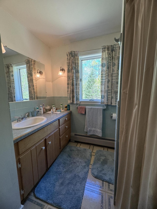 898 Sebec Village Rd, Sebec, ME 04481 - full bathroom with a baseboard heating unit, tile walls, vanity, and wainscoting