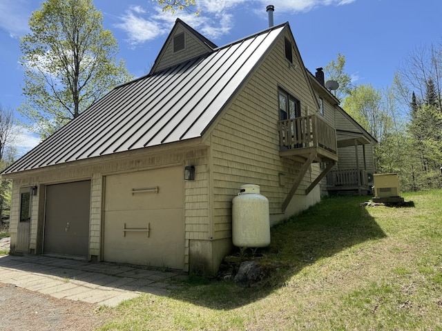898 Sebec Village Rd, Sebec, ME 04481 - view of property exterior featuring a standing seam roof, metal roof, a chimney, a detached garage, and a lawn