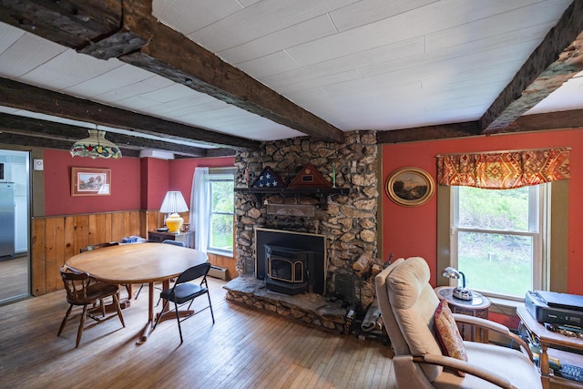 168 Beech Hill Rd, Auburn, ME 04210 - dining area with hardwood / wood-style floors, a wood stove, wainscoting, beam ceiling, and baseboard heating