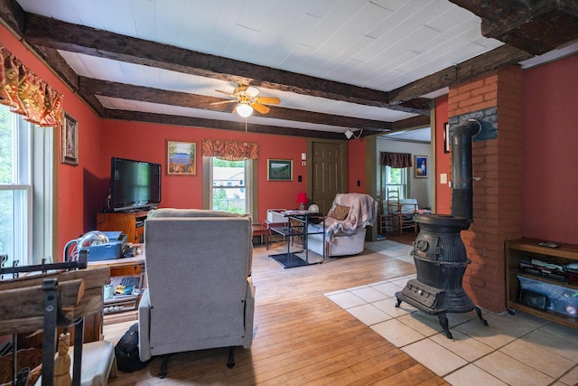 168 Beech Hill Rd, Auburn, ME 04210 - living room with beamed ceiling, a wood stove, a ceiling fan, and light wood finished floors