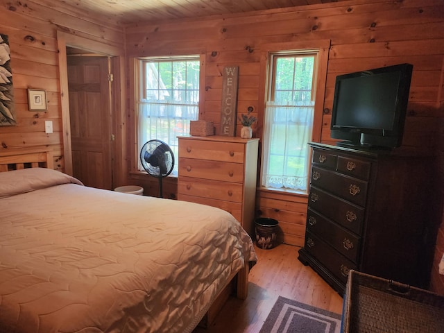 227 Brooks Pond Dr, Corinna, ME 04928 - bedroom featuring wood walls, multiple windows, wooden ceiling, and light wood-style floors
