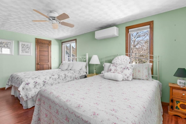 73 Wards Cove Rd, Standish, ME 04084 - bedroom with a wall mounted AC, multiple windows, wood finished floors, and a ceiling fan